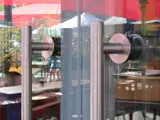 Close‑up of stainless‑steel handles on the frameless glass façade at London’s Royal Festival Hall.