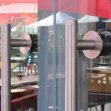 Close‑up of stainless‑steel handles on the frameless glass façade at London’s Royal Festival Hall.